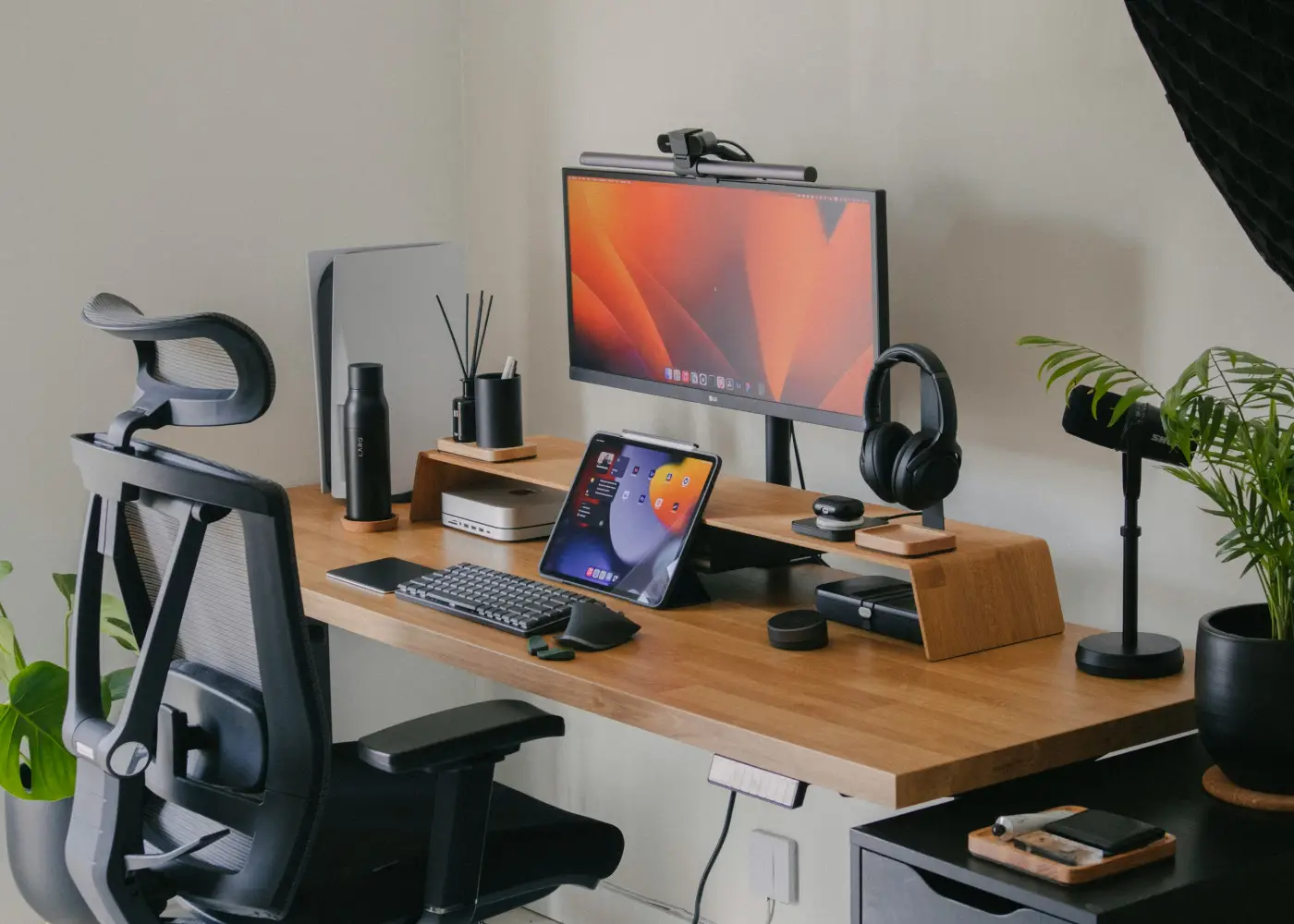 A desk setup with monitor, laptop and headphones
